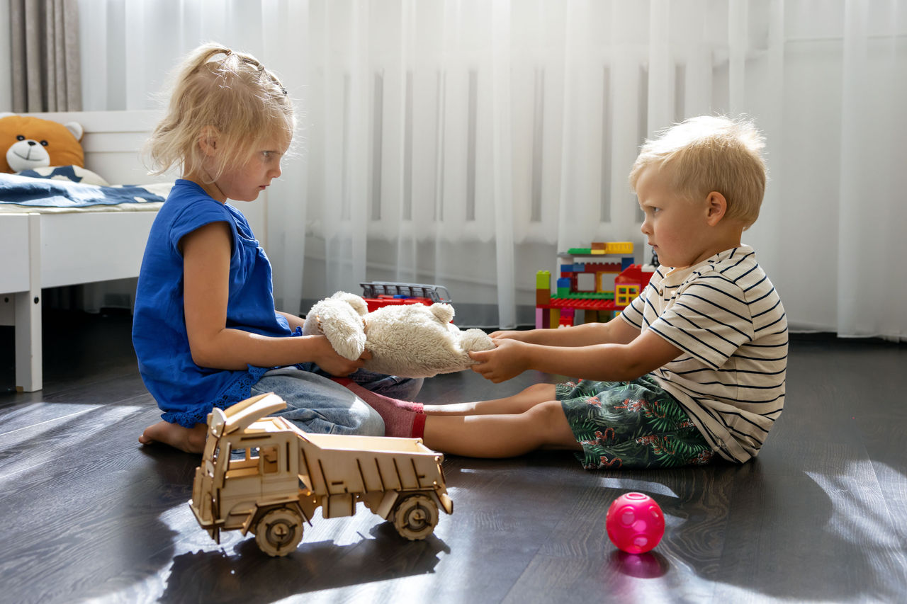 Two children arguing over a sharing a toy