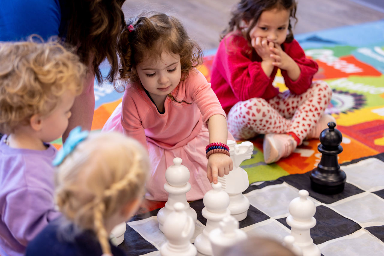 Group of Goddard preschool students playing chess