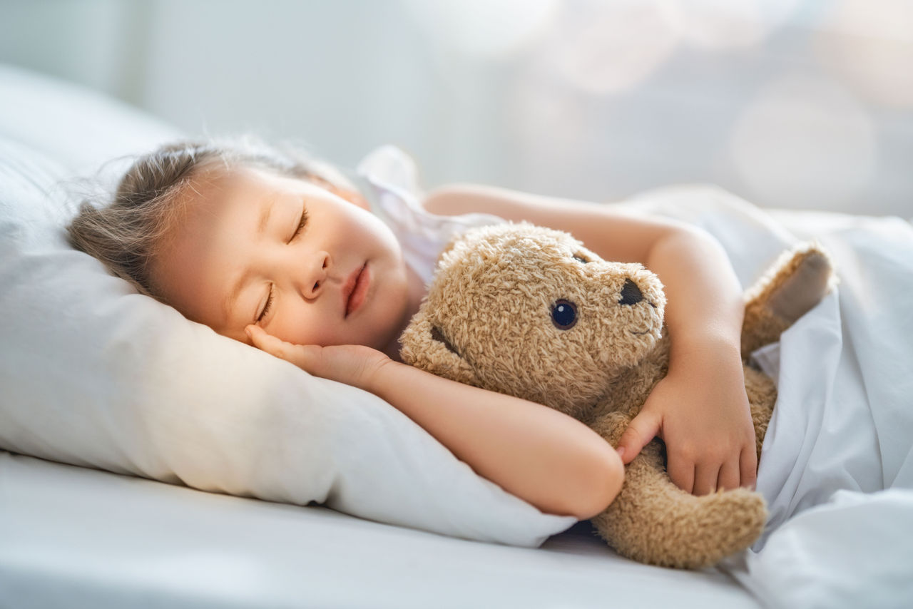 Sleeping child holding a teddy bear