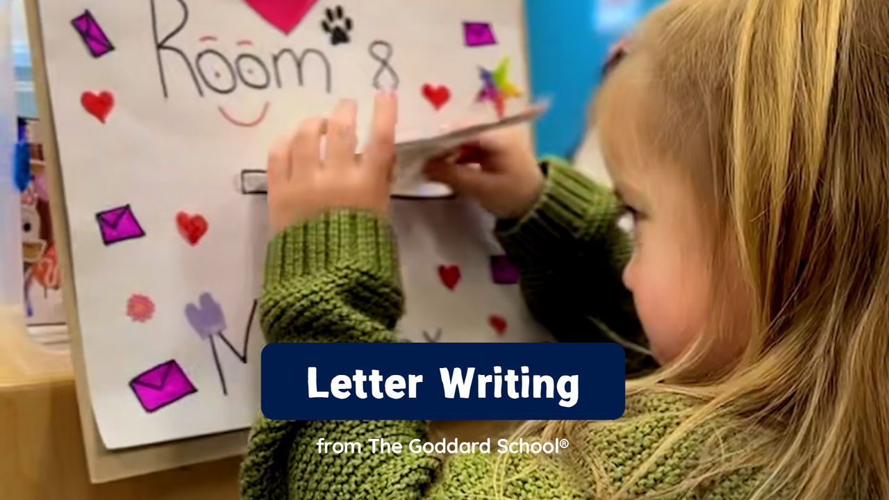 A young girl placing a letter she wrote into a teacher-made mailbox in her preschool classroom.