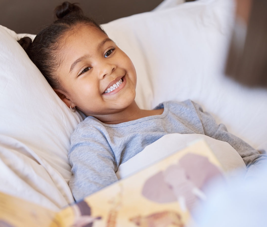 Young girl in bed listening to a story