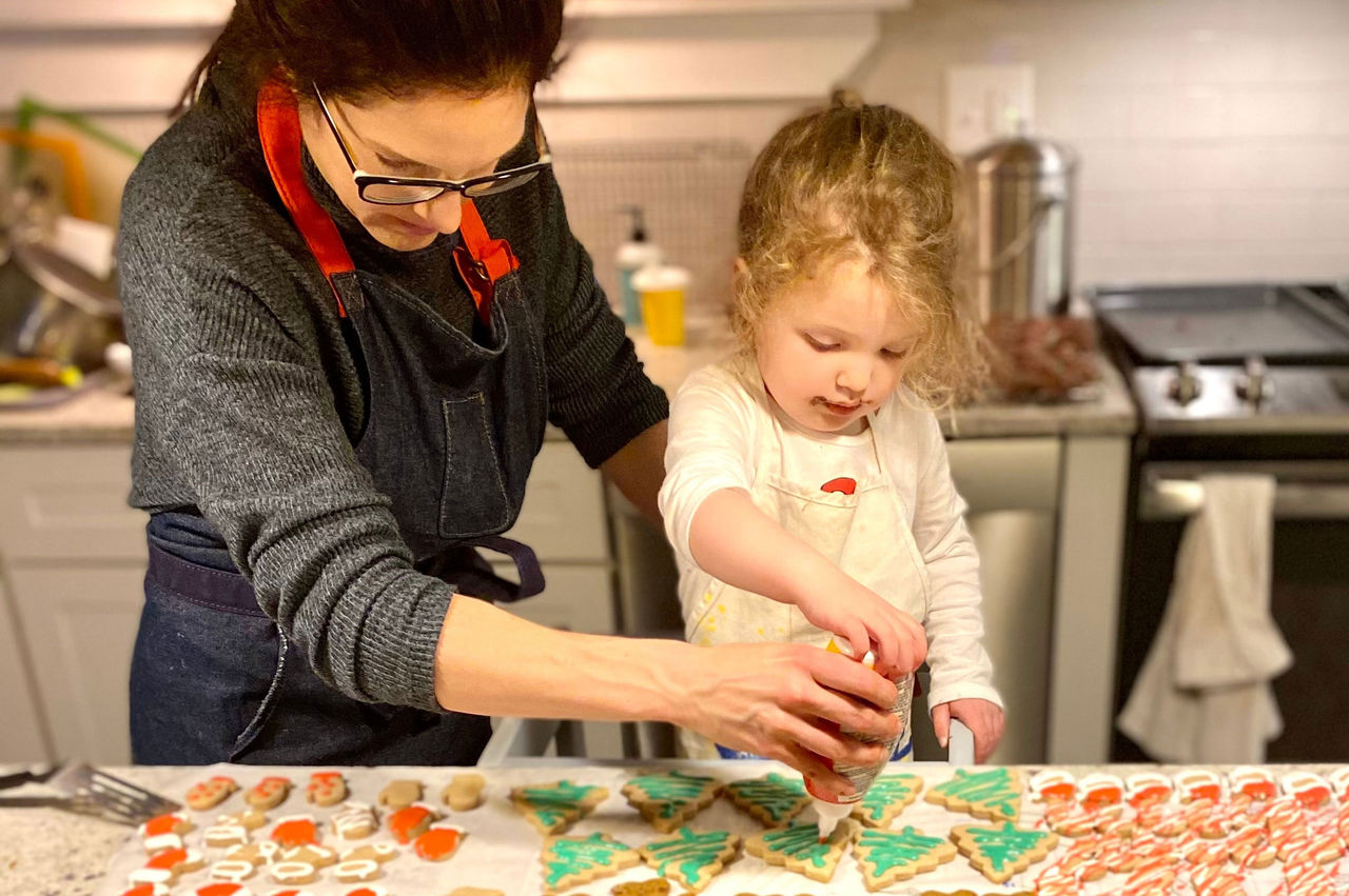 Mother and daughter decorating holiday cookies