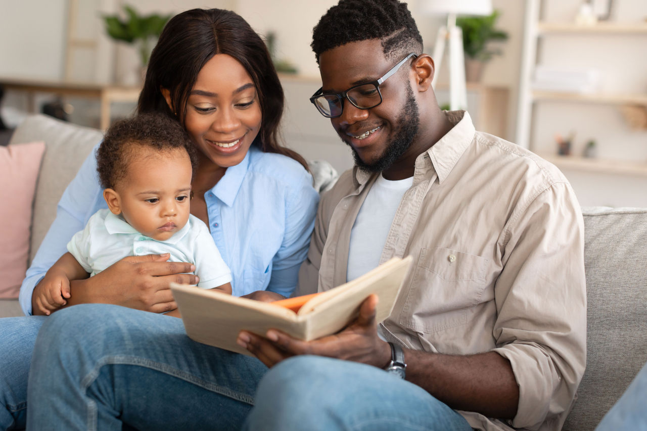 Parents reading a book with their infant