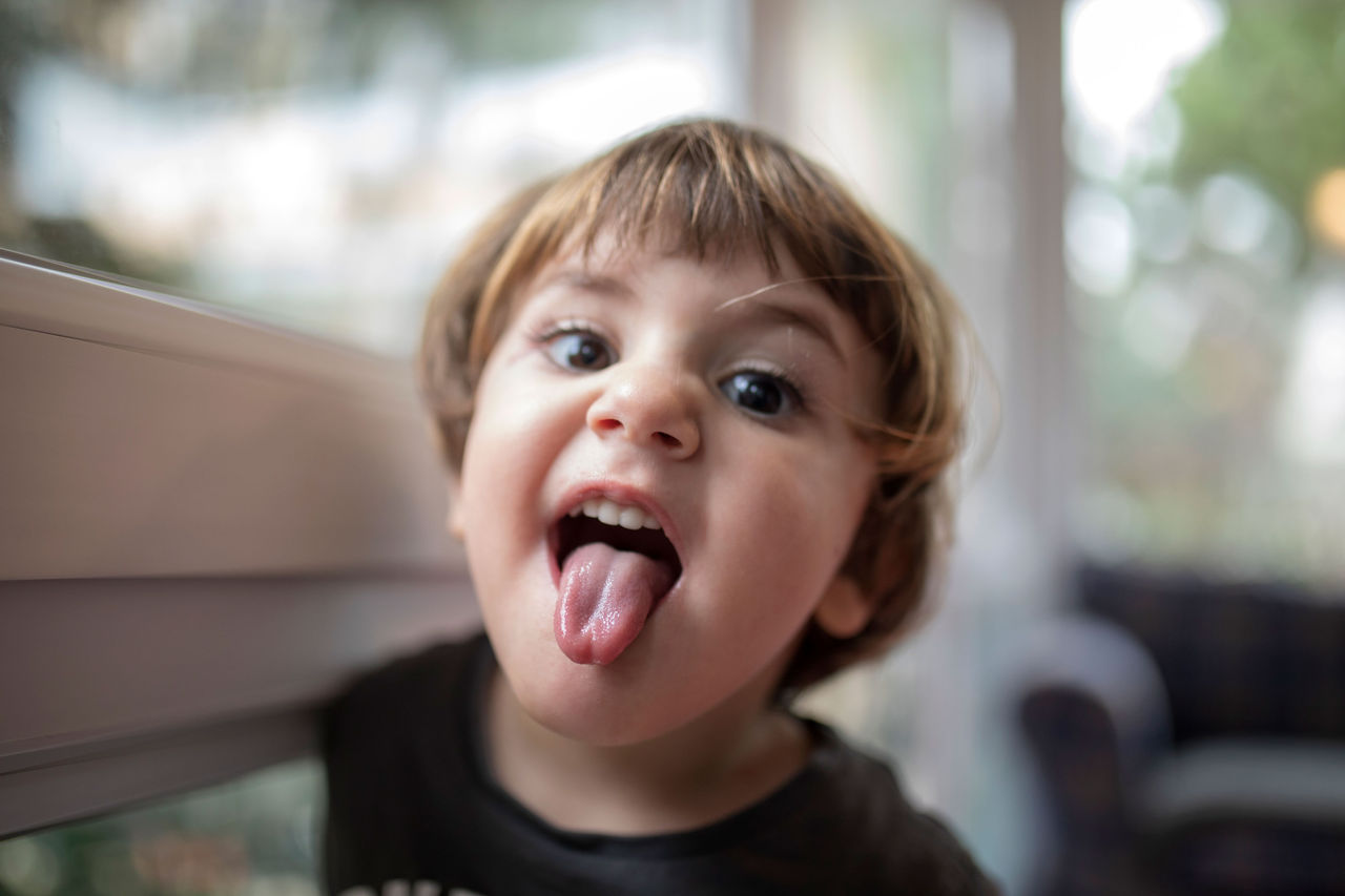 A young child sticking their tongue out