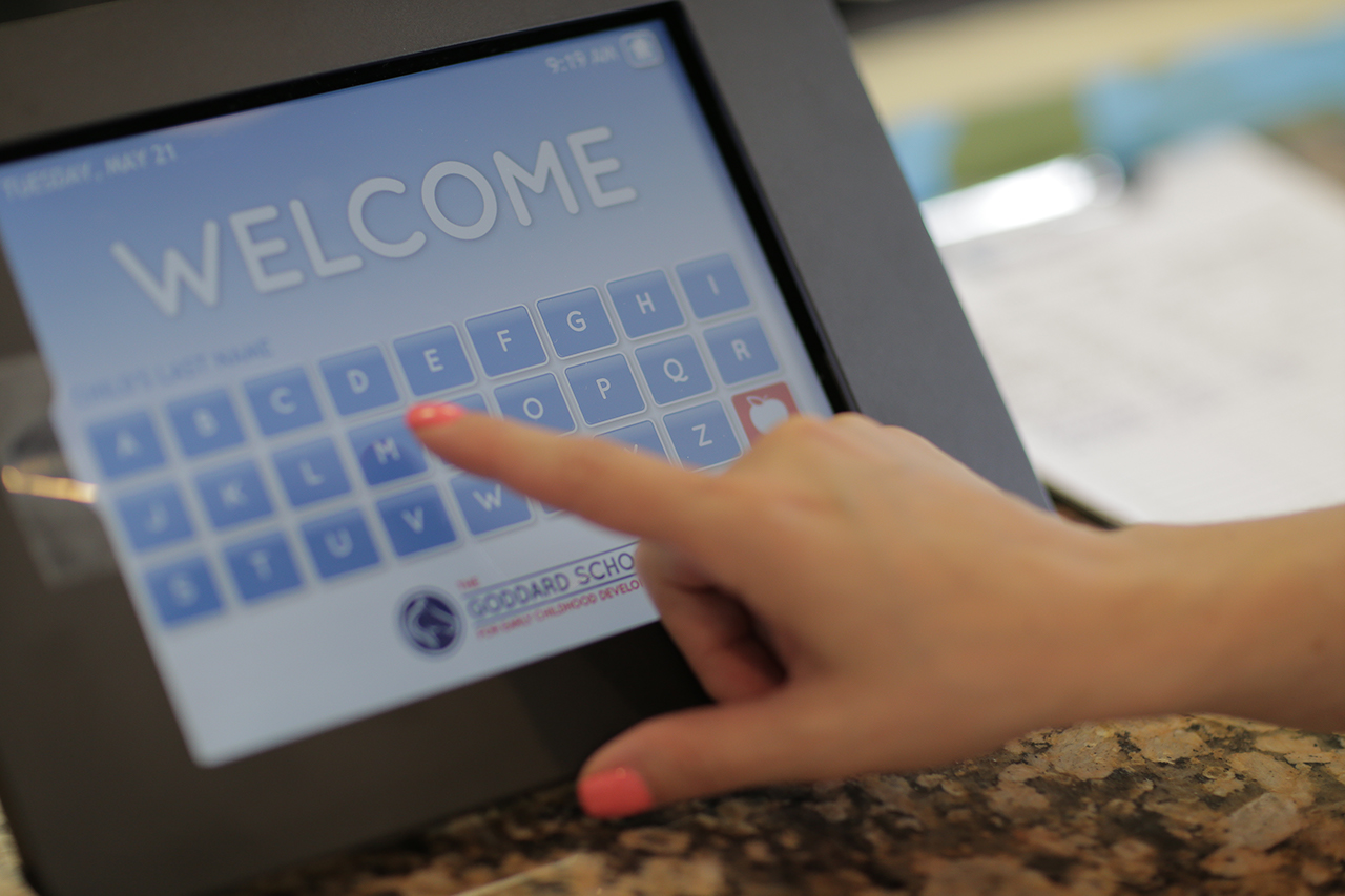 A hand tapping on a tablet with a locked welcome screen, asking for a security password.