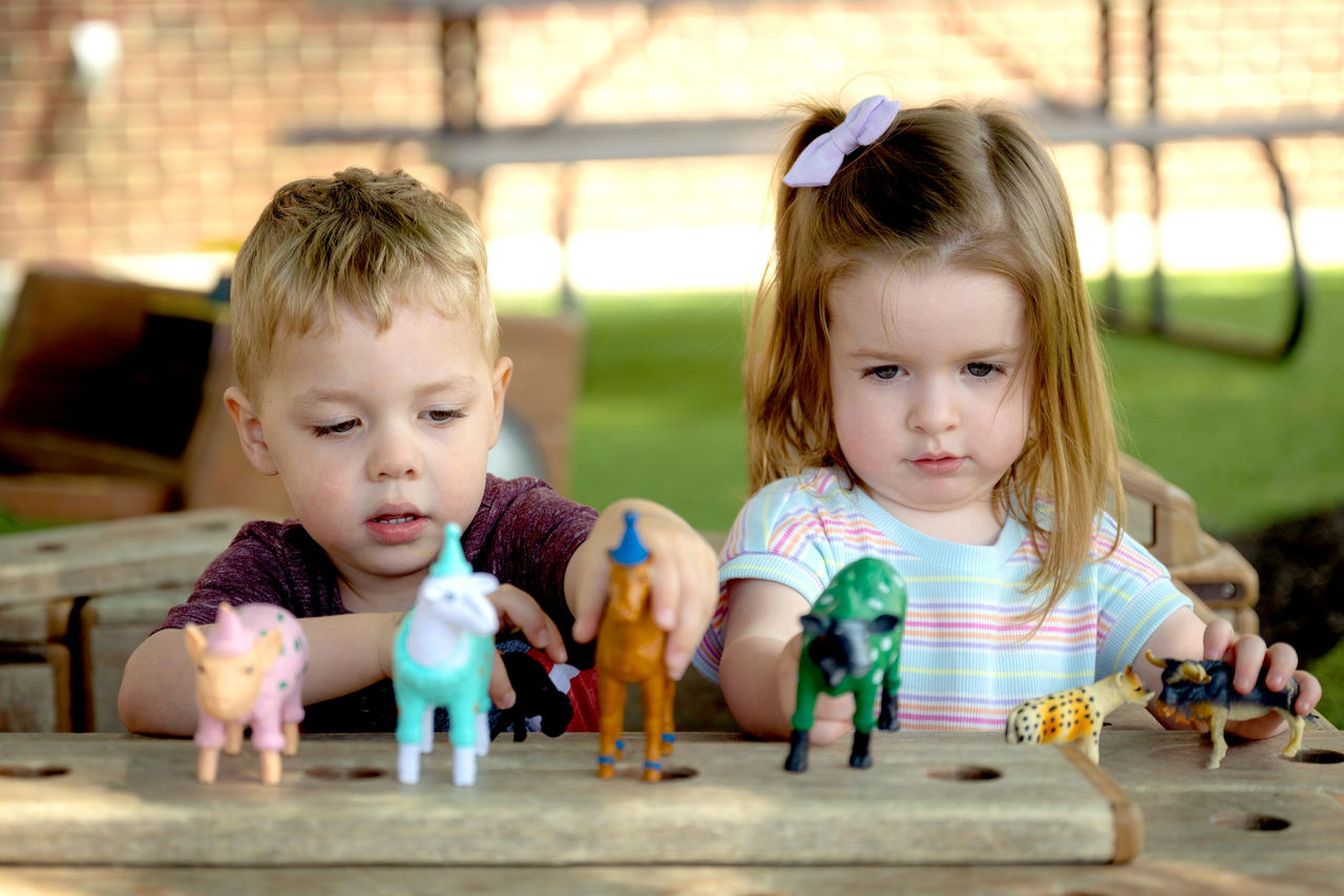 Two children playing with toy animals